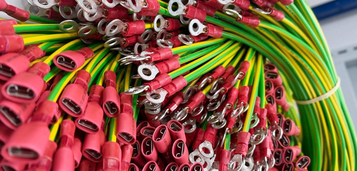 Cluster of finished cable assemblies. Green and yellow cables with connectors attached.