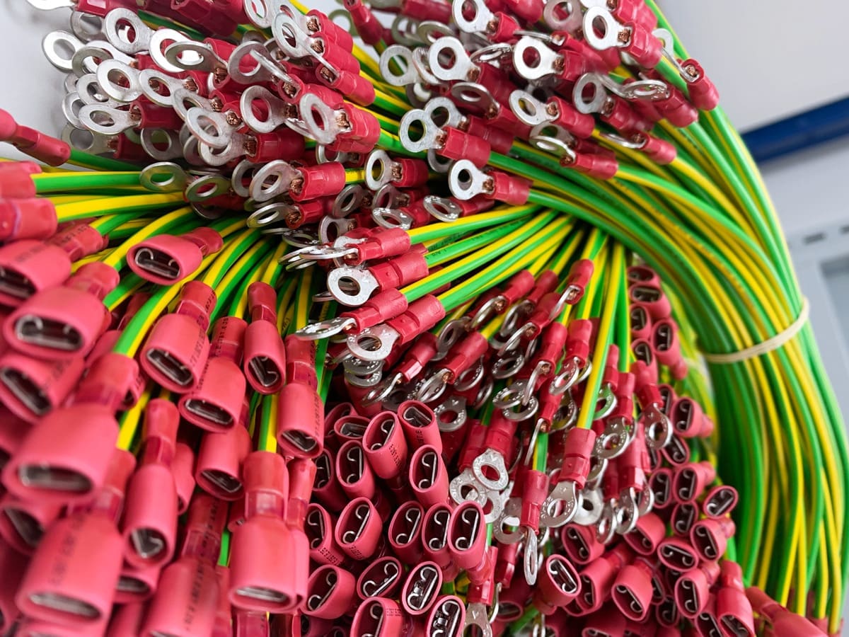 Cluster of finished cable assemblies. Green and yellow cables with connectors attached.