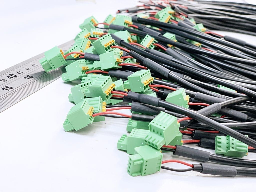 A group of wires with connectors on a white electronics work bench