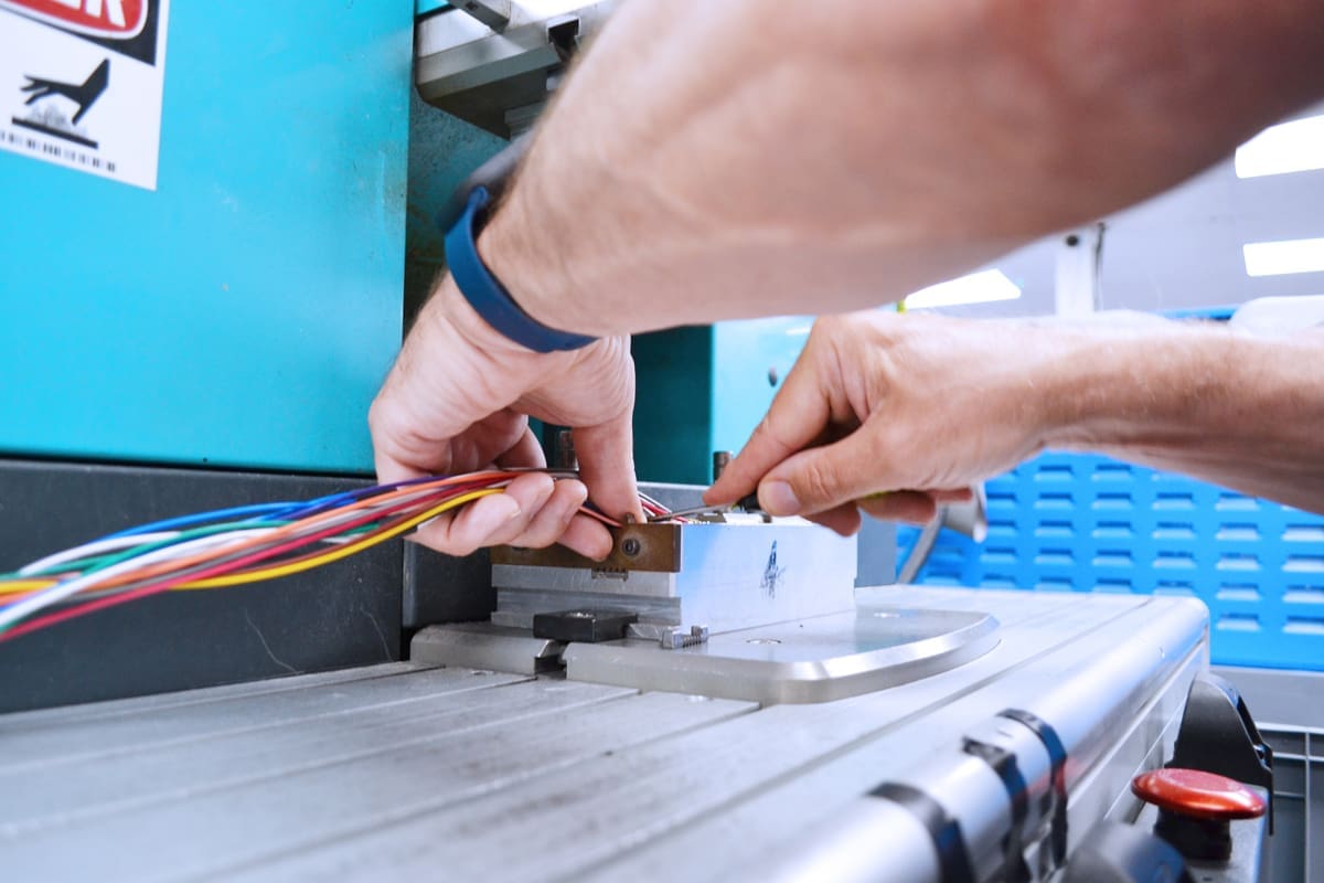 Cable assembly being positioned into a form ready for overmolding.